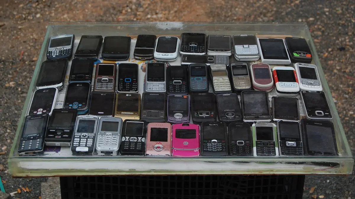 Second-hand mobile phones laid out on a stall in Prishtina